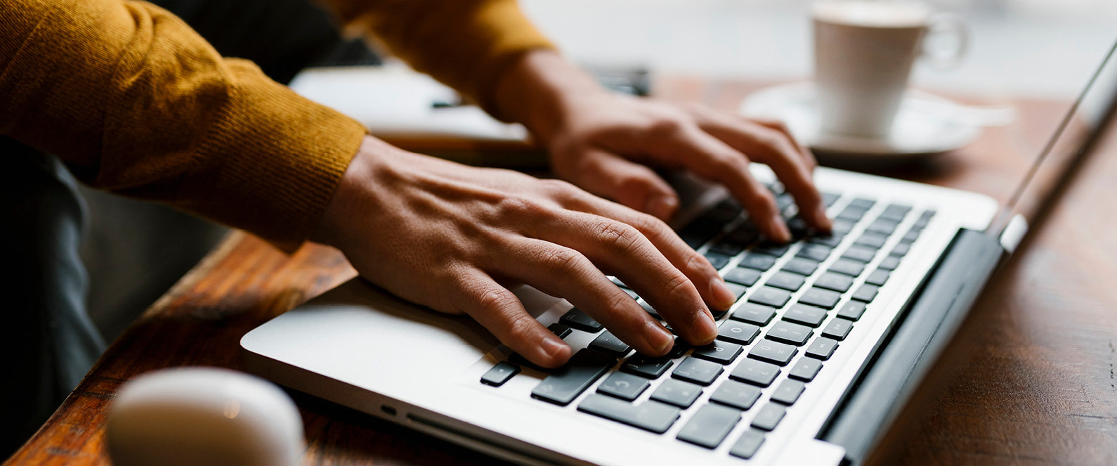 Person tippt an Laptoptastatur