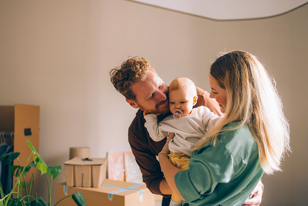 Eine junge Familie mit ihrem Kind in ihrem neuen Zuhause. 