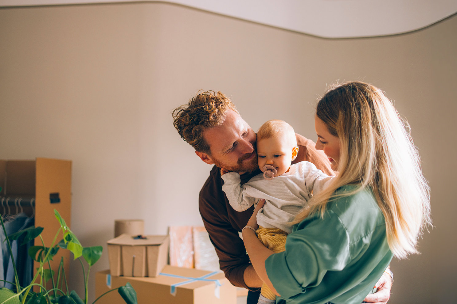 Eine junge Familie mit ihrem Kind in ihrem neuen Zuhause. 