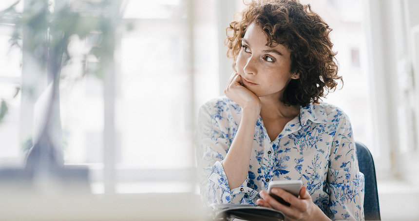 Frau wählt eine Nummer an Handy