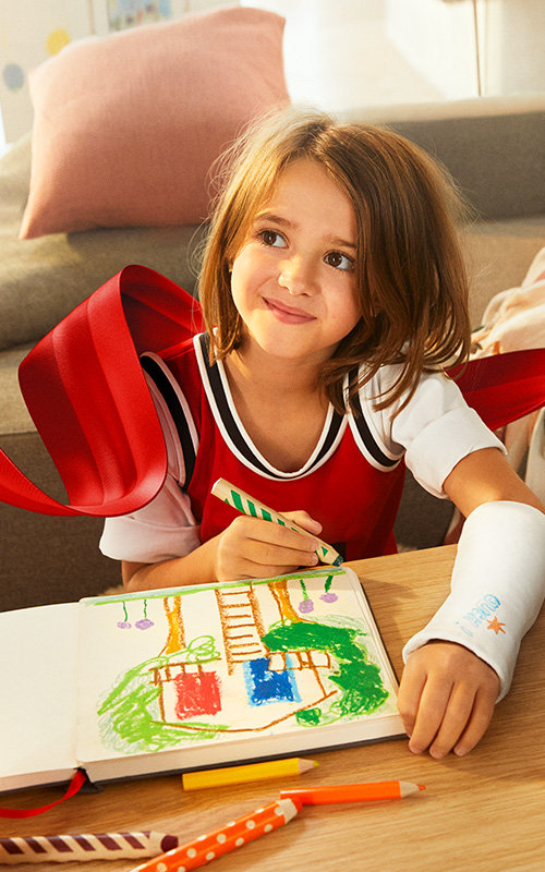 Ein Mädchen malt ihre Träume in ein Buch und lächelt. 