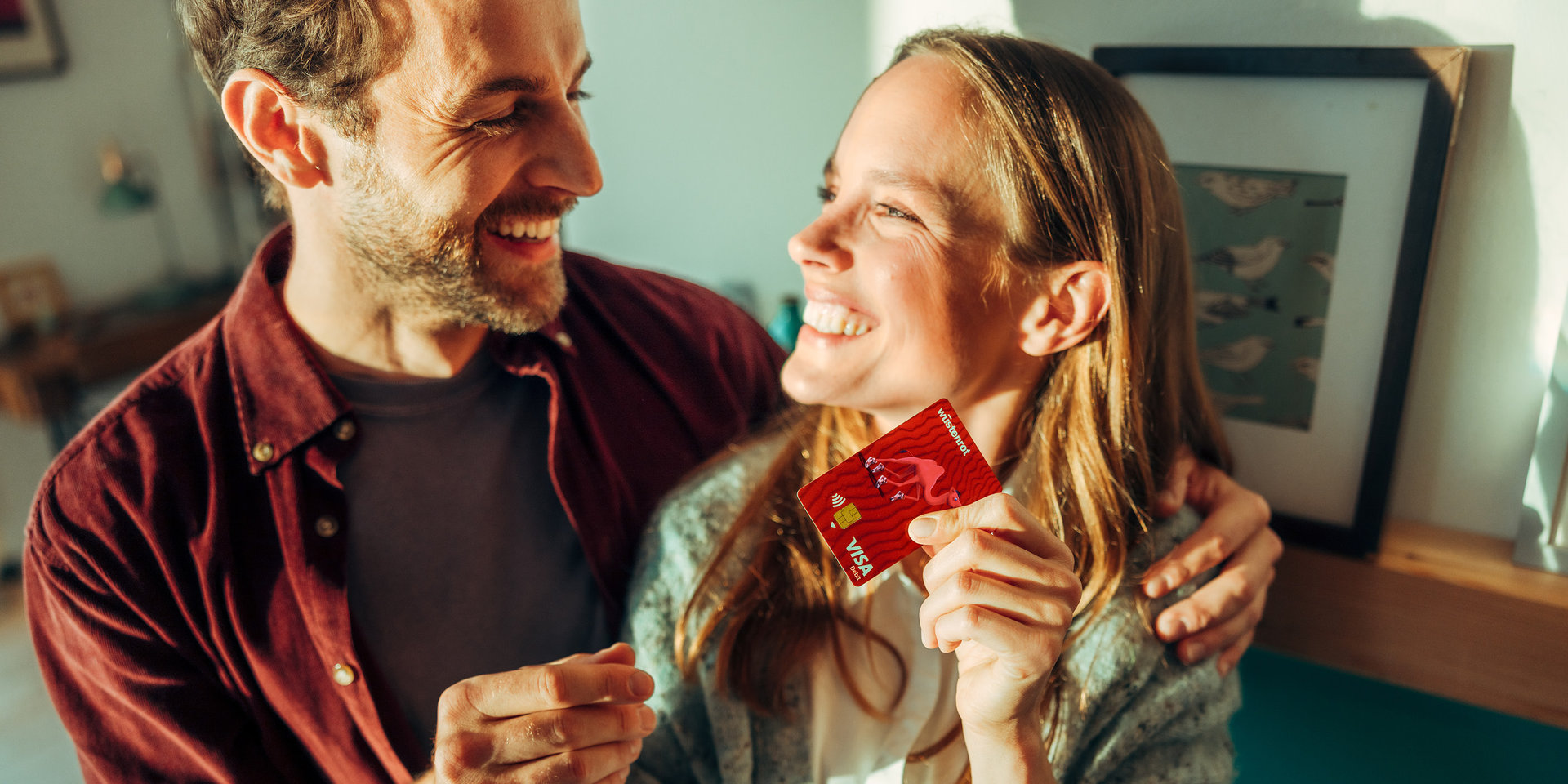 Paar lachend hält Kreditkarte in der Hand