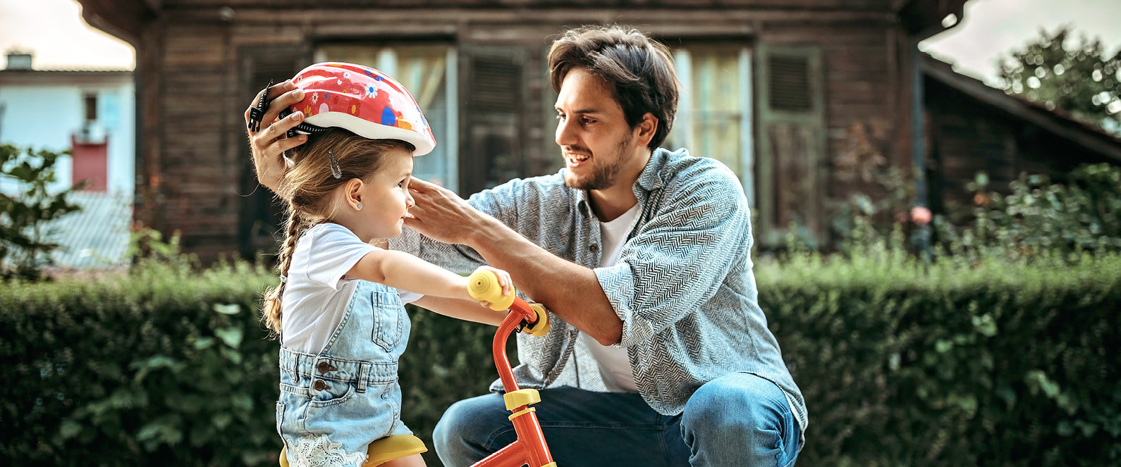 Vater setzt Tochter Fahrradhelm auf