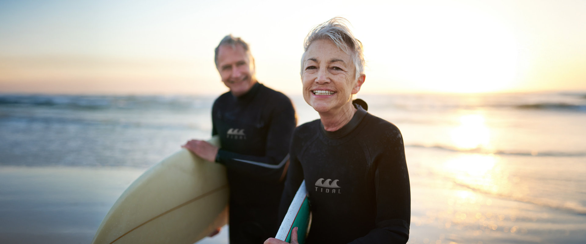 Eine ältere Frau und ein Mann genießen das Leben beim Surfen.