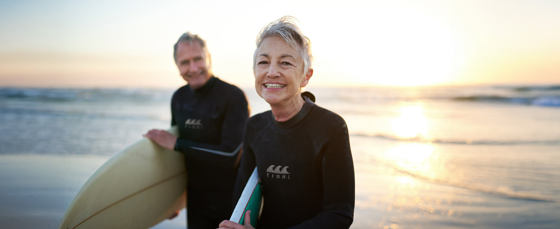 Eine ältere Frau und ein Mann genießen das Leben beim Surfen.