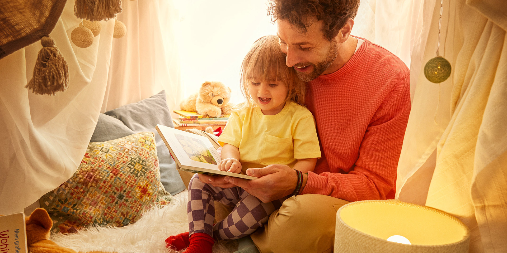 Vater mit Tochter beim Lesen