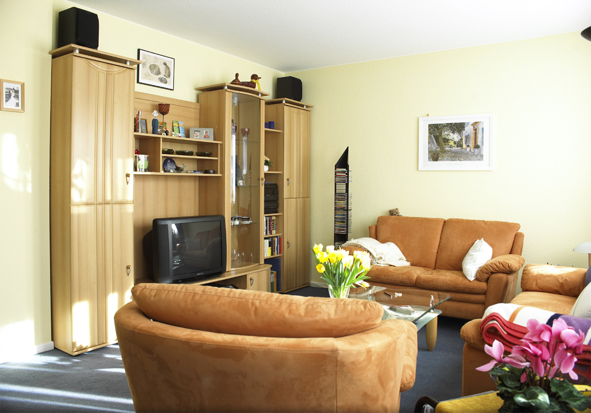 Ein Wohnzimmer mit Röhrenfernseher und Schrankwand