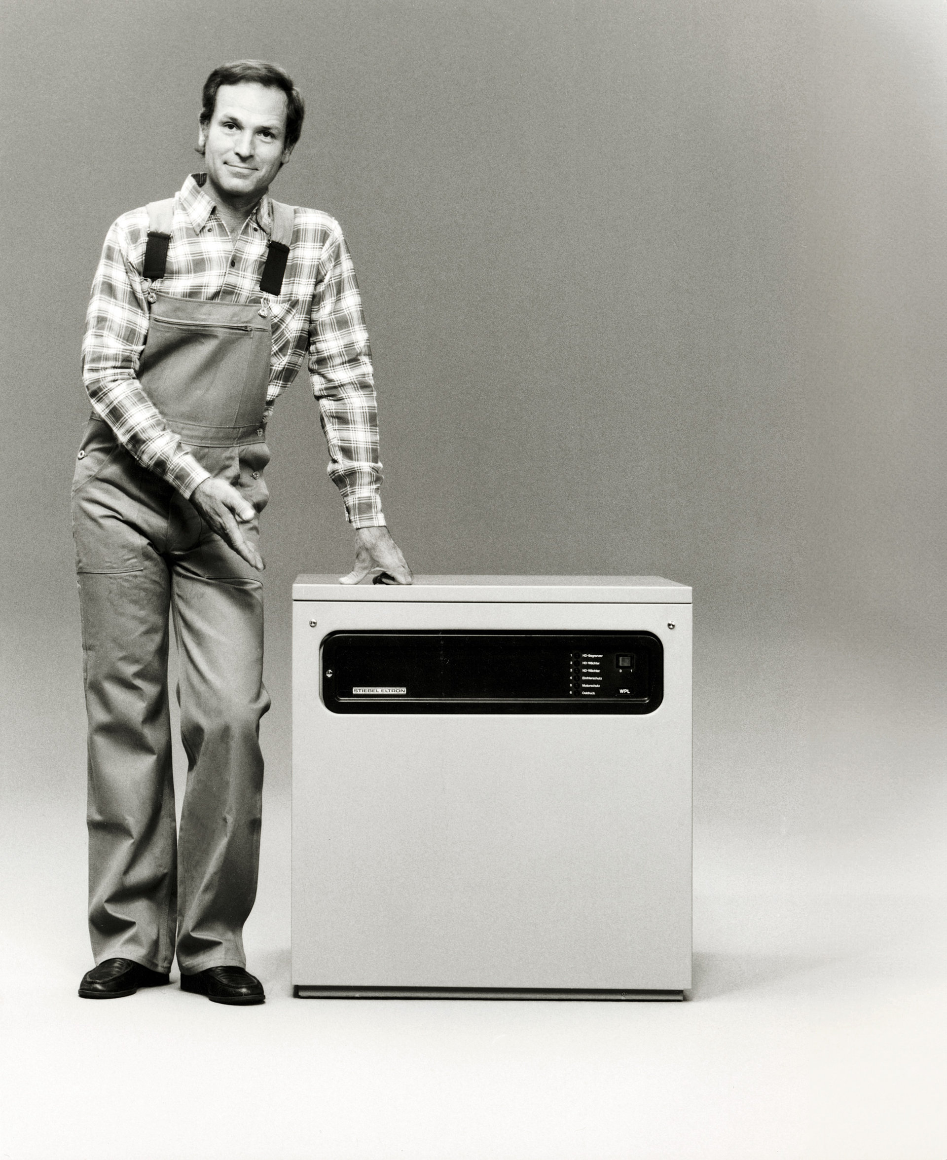 Szene aus der historischen Markenwerbung von Stiebel Eltron: Ein Mann zeigt auf ein Haushaltsgerät