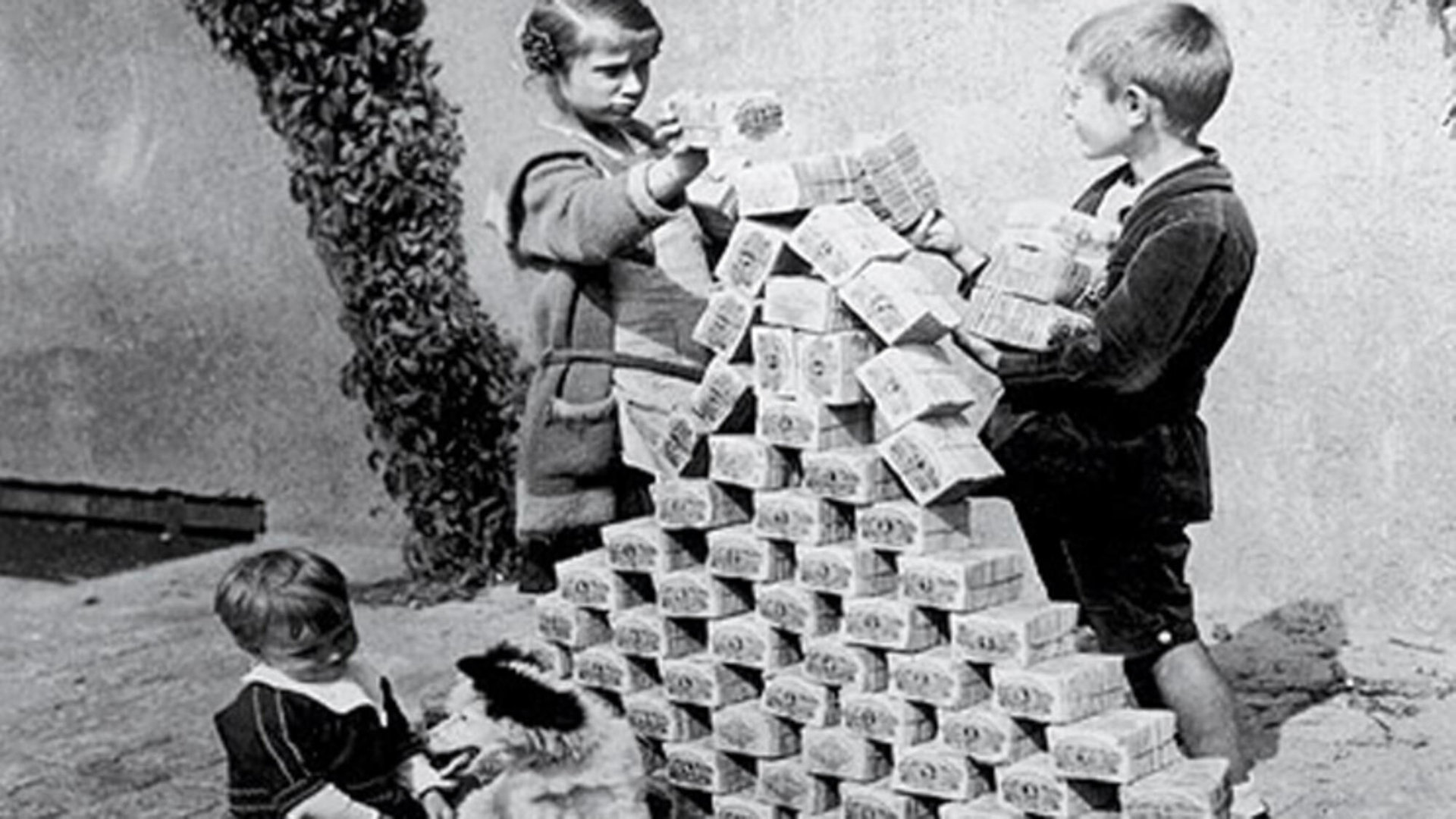Hyperinflation: Geld verliert seinen Wert Kinder spielen mit Bündeln von Gedscheinen