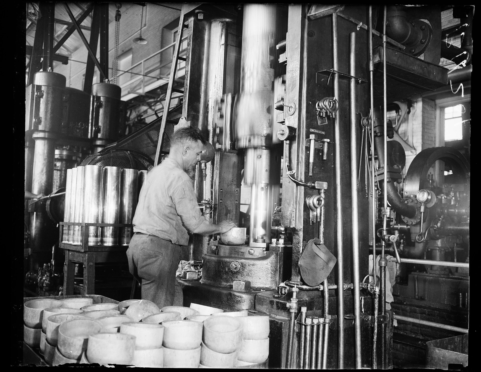 Schwarz weiß Foto von einem Mann der an einer Industriemaschine arbeitet