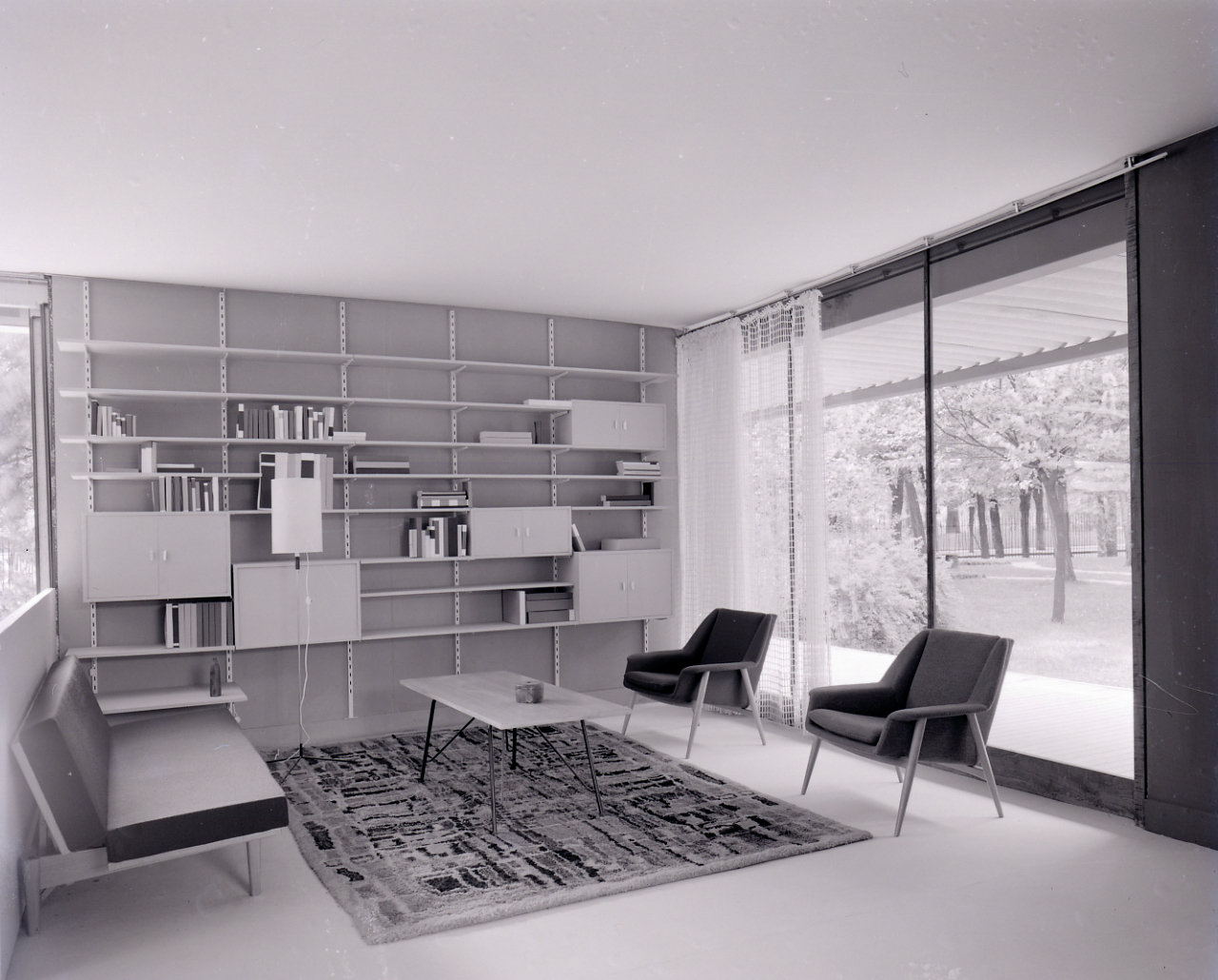 Schwarz-Weiß-Aufnahme eines Wohnzimmers möbiliert in minimalistischem Stil in