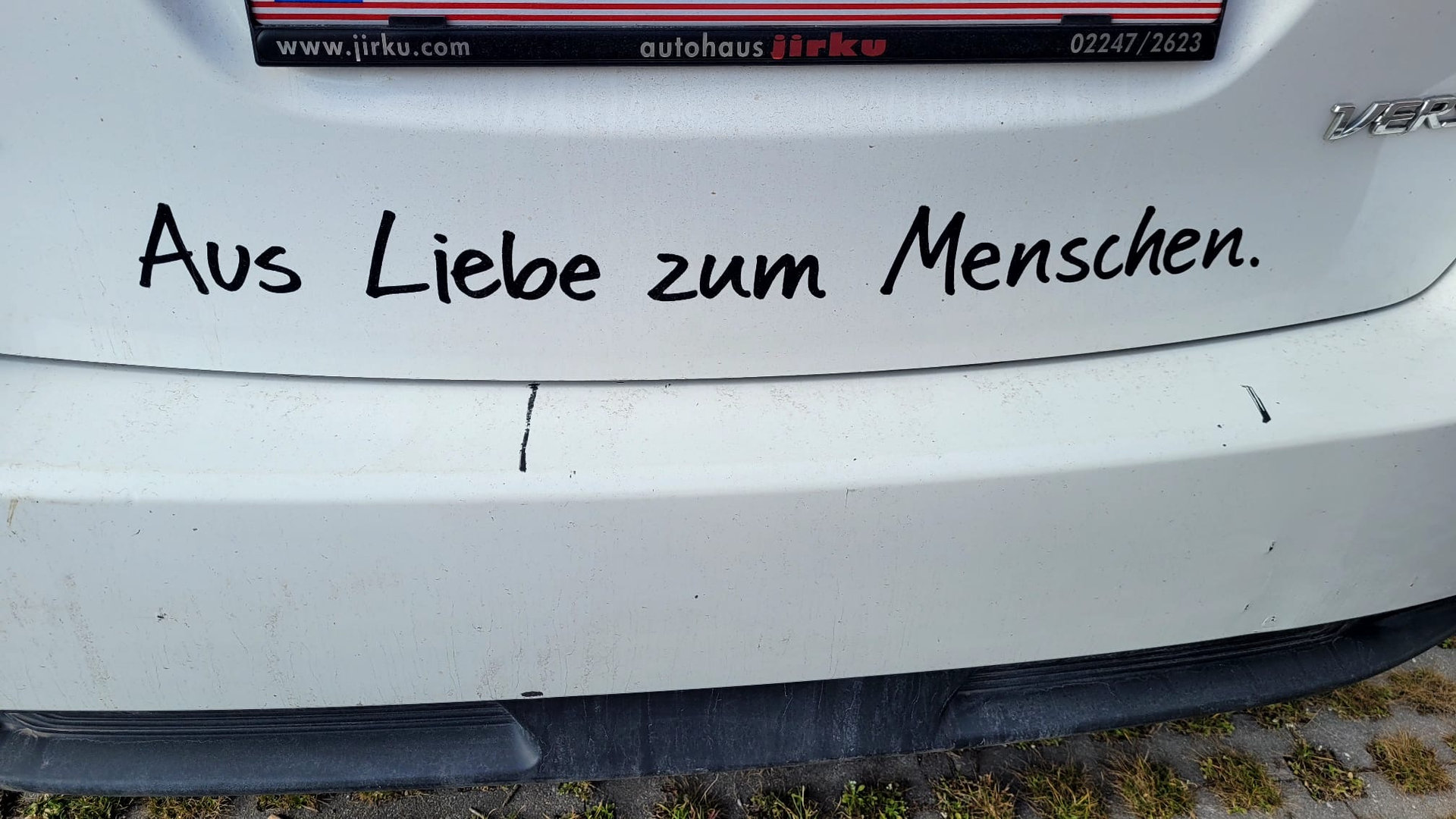 Aufschrift Aus Liebe zum Menschen auf einem Auto des Roten Kreuzes
