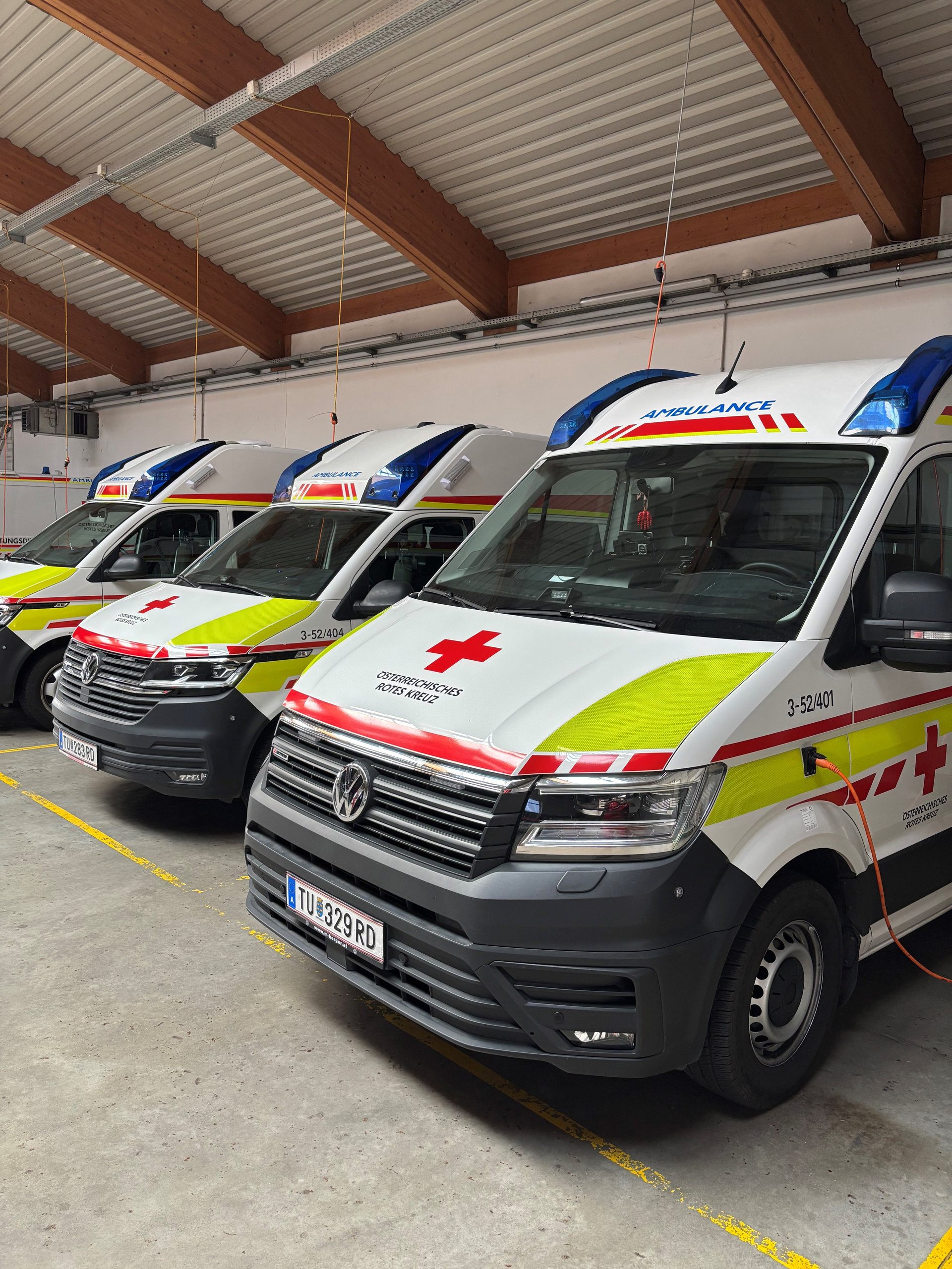 Drei Einsatzfahrzeuge des Roten Kreuzes in einer Garage