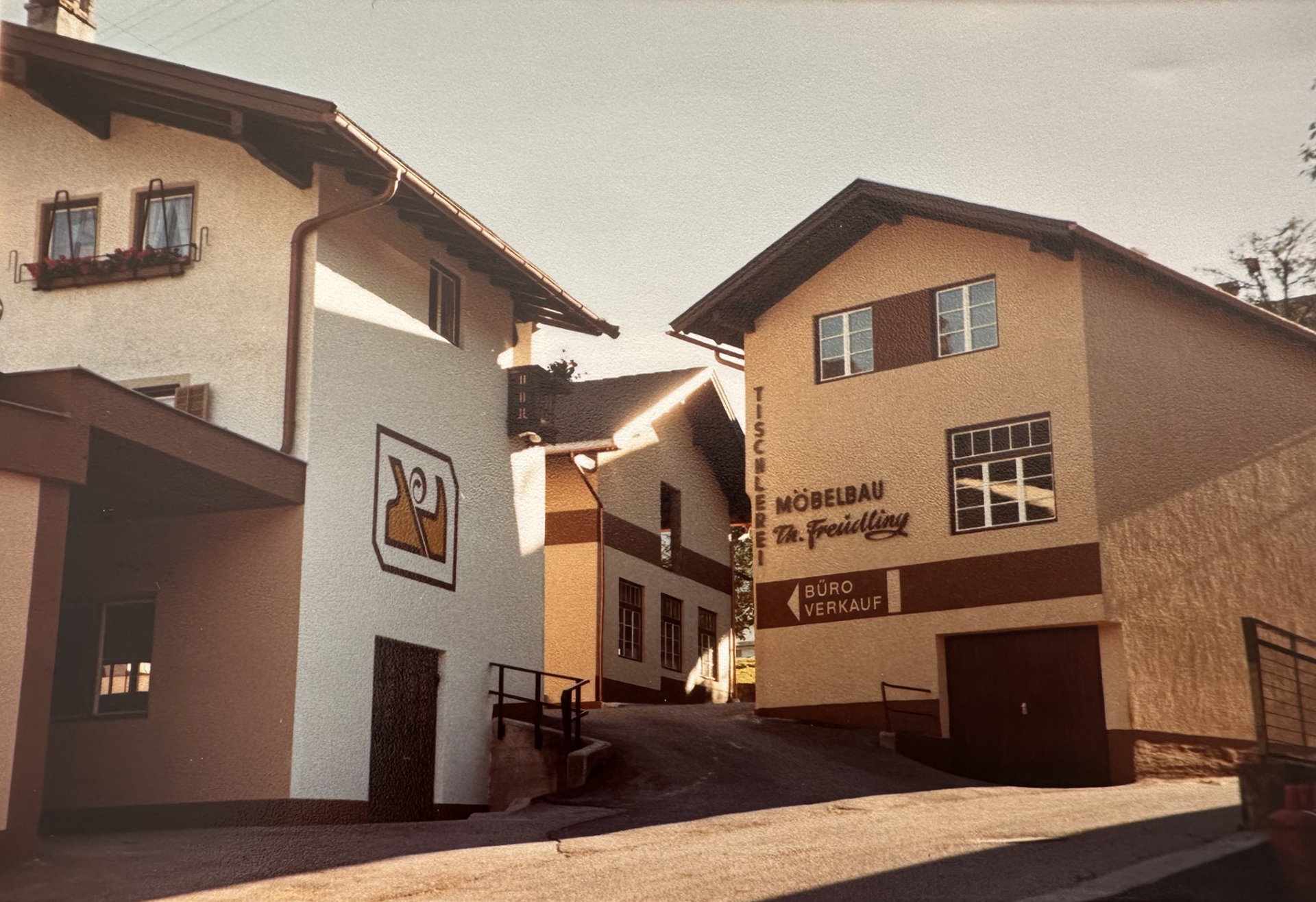 Historische Aufnahme aus dem Jahr 1973: Drei nebeneinander stehende Gebäude der Firma Freudling Wohndesign.