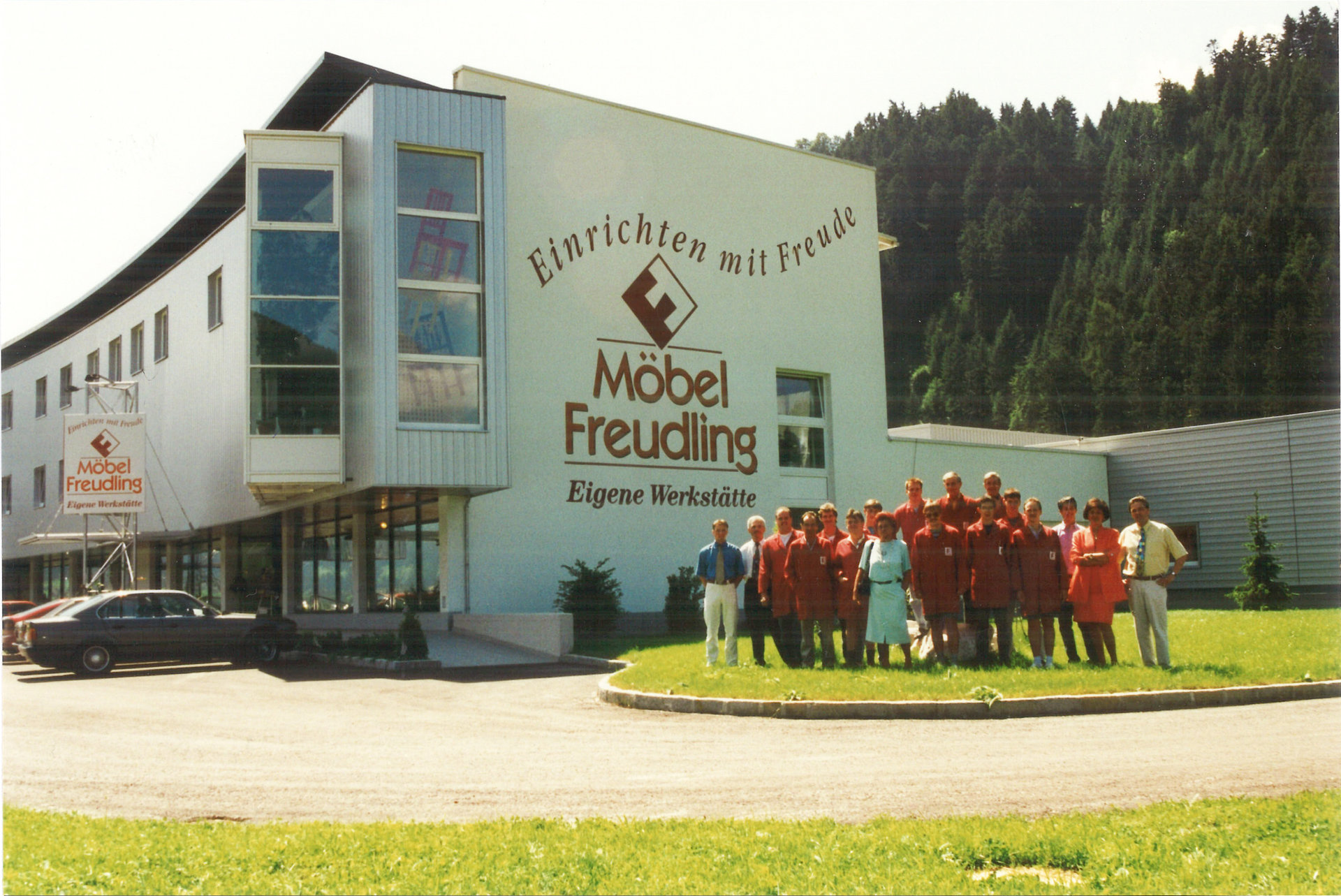 Seitenansicht des Firmengebäudes von Freudling Wohndesign im Jahr 1995 – mehrere Mitarbeitende stehen davor.