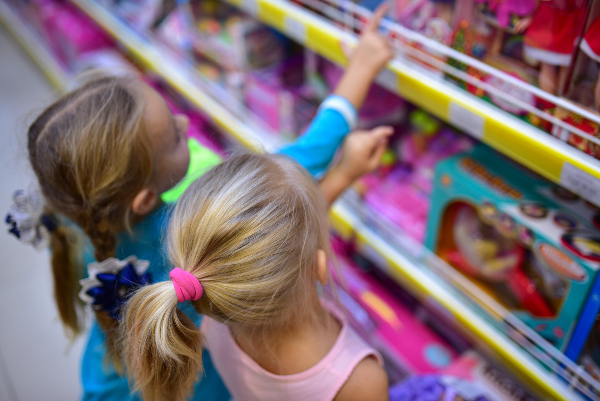 Kleine Kinder beobachten die Spielzeuge auf dem Ladentisch