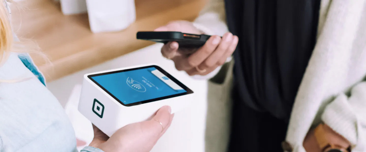 Eine Person bezahlt etwas mit ihrem Handy 