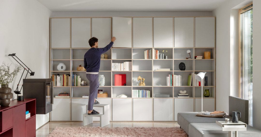 Mann sucht etwas in seinem Regal