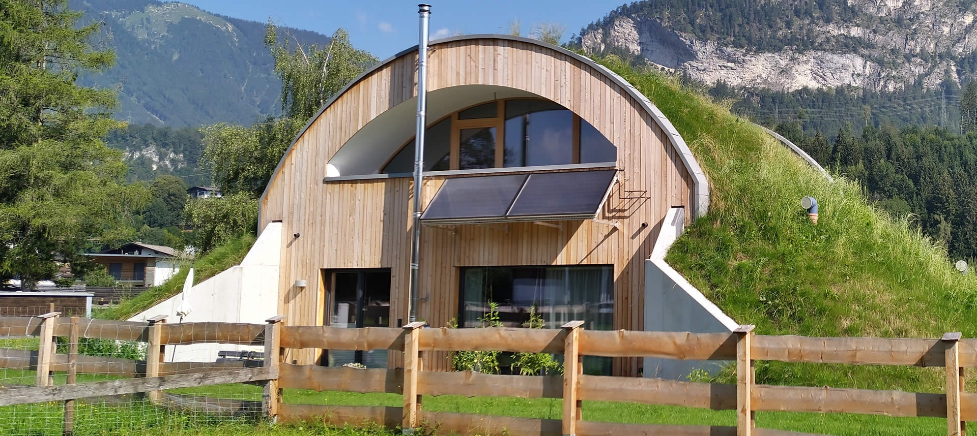 Ein Hügelhaus, auf dem Rasen wächst.