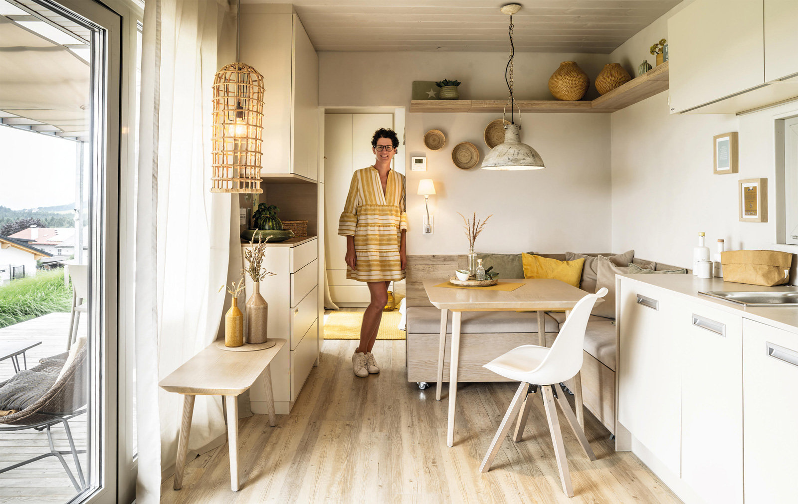 Eine Frau steht in der Wohnküche in einem Mikrohaus