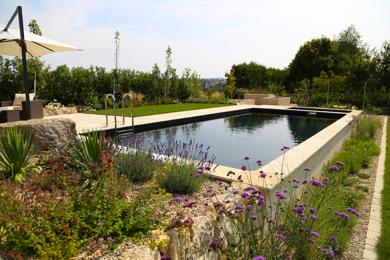 Ein Naturpool reinigt Wasser ohne Pflanzen im Becken.