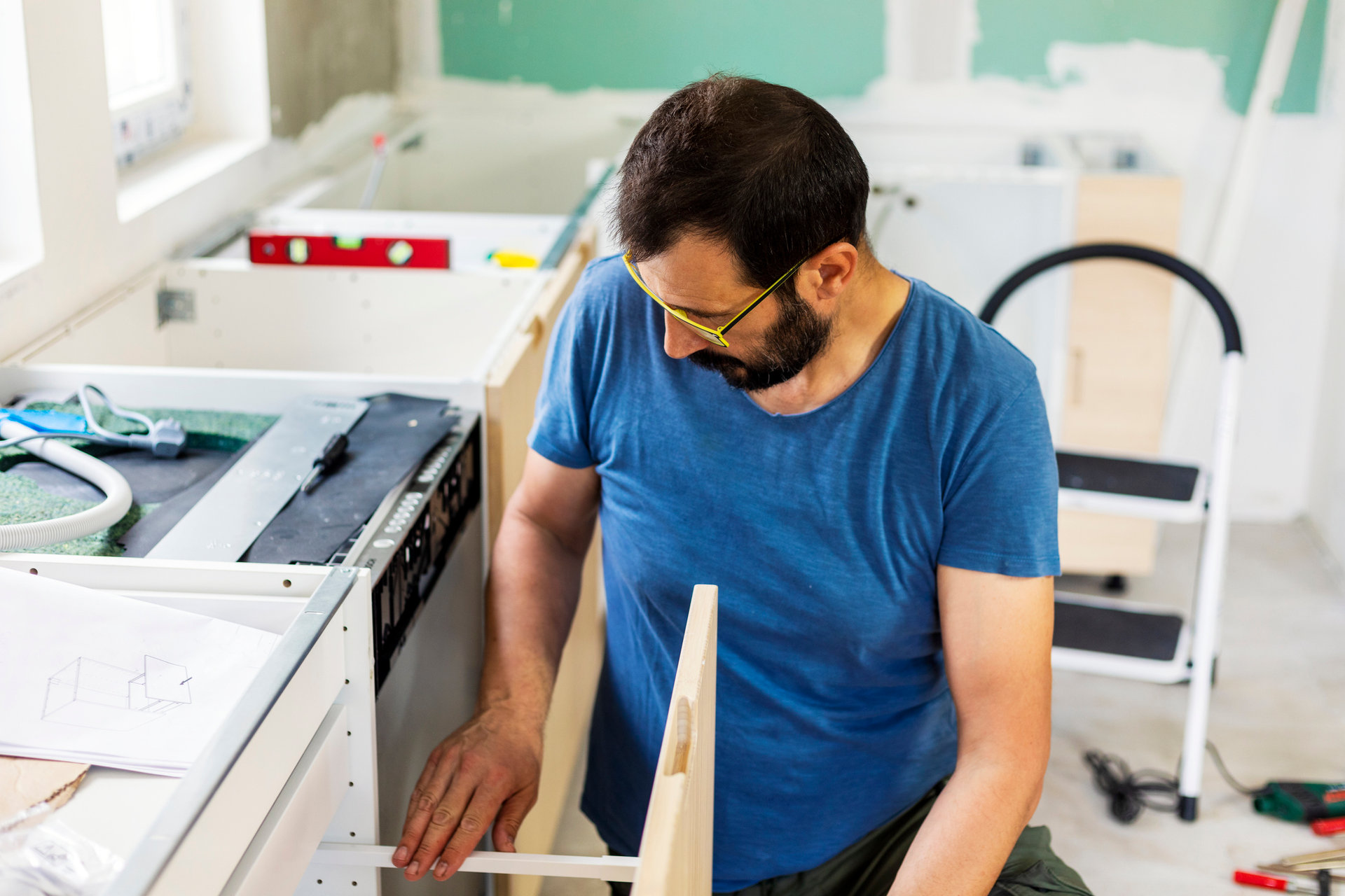 Ein Handwerker justiert eine Schublade in einer Küche