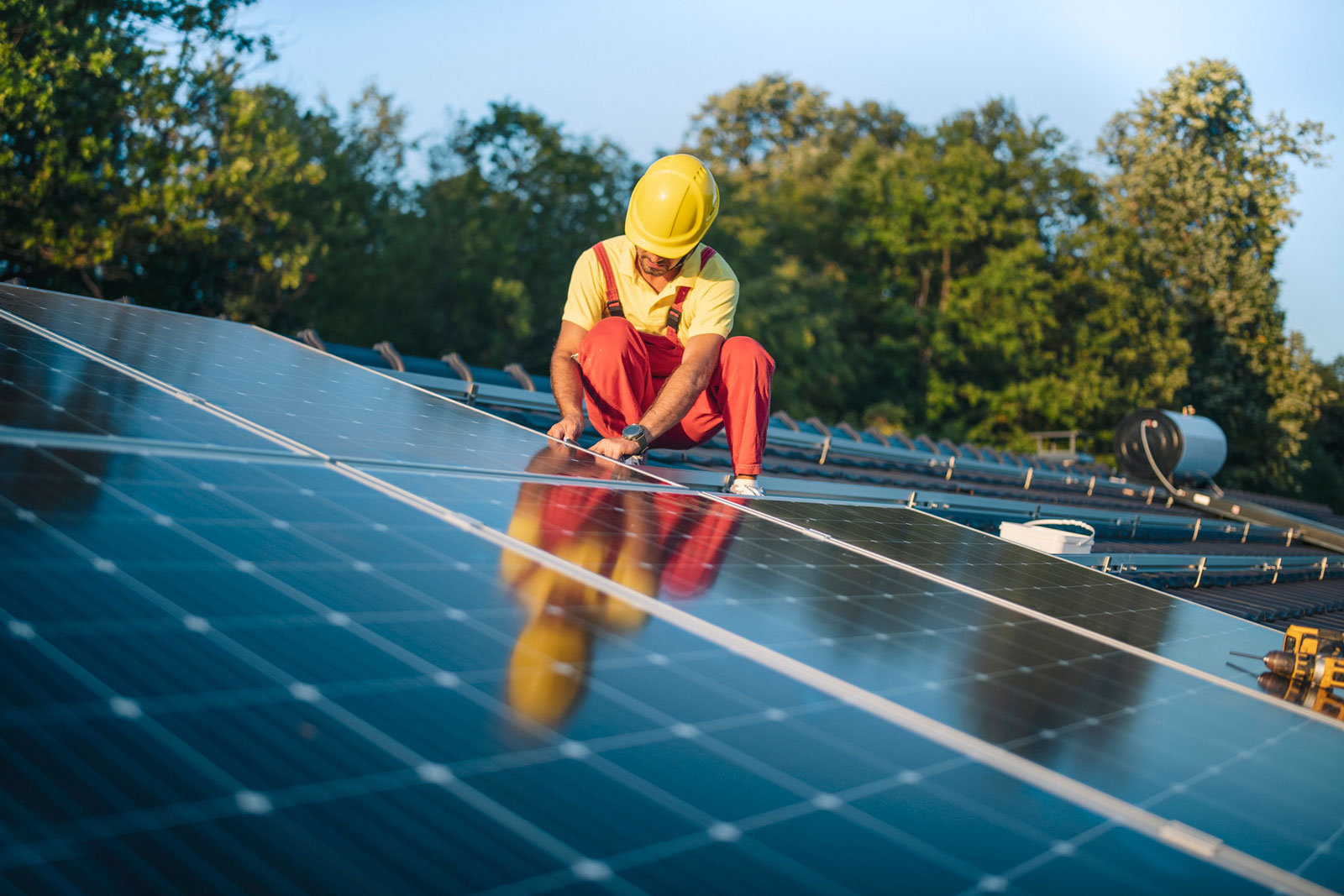 Arbeiter installiert Solarpanele auf einem Dach.