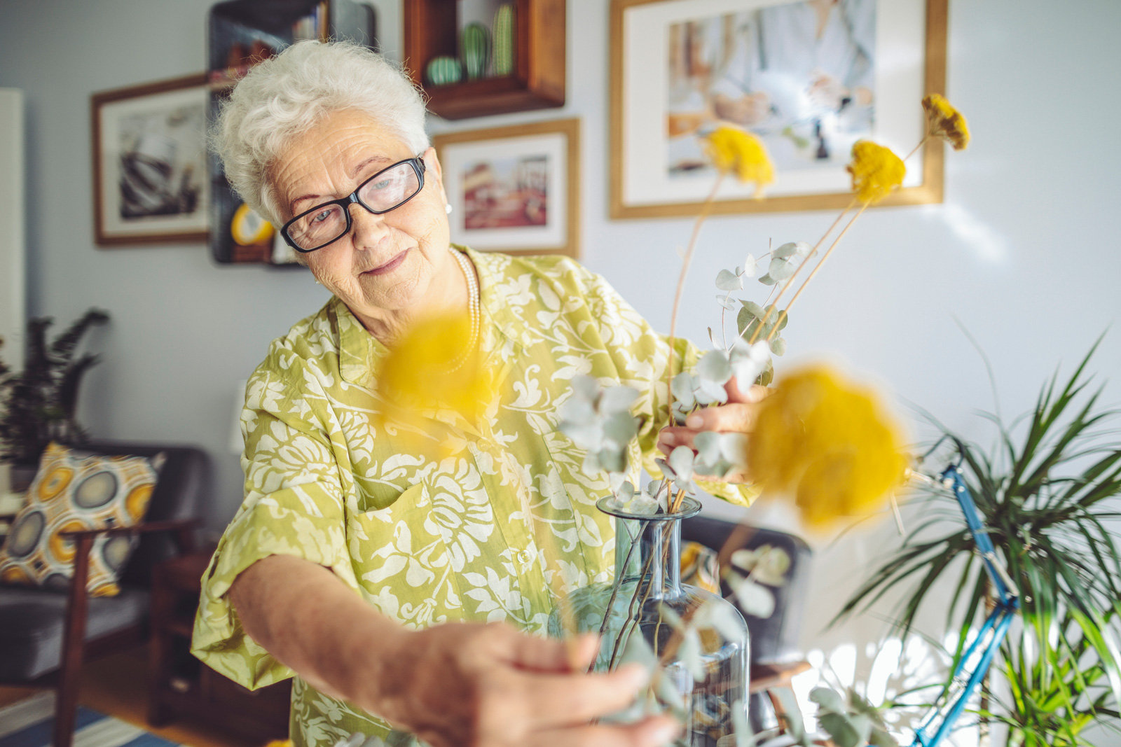 alte Frau arrangiert Blumen ín einer Vase