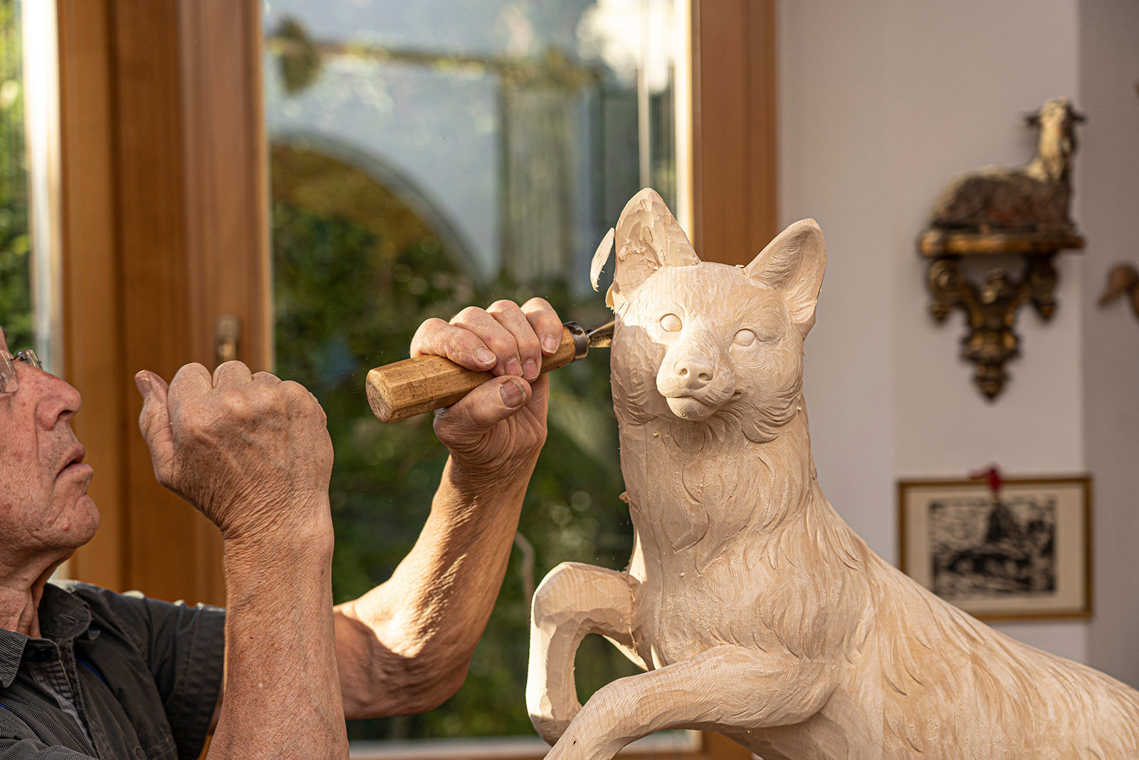 Ein Handwerker schnitzt eine Tierfigur