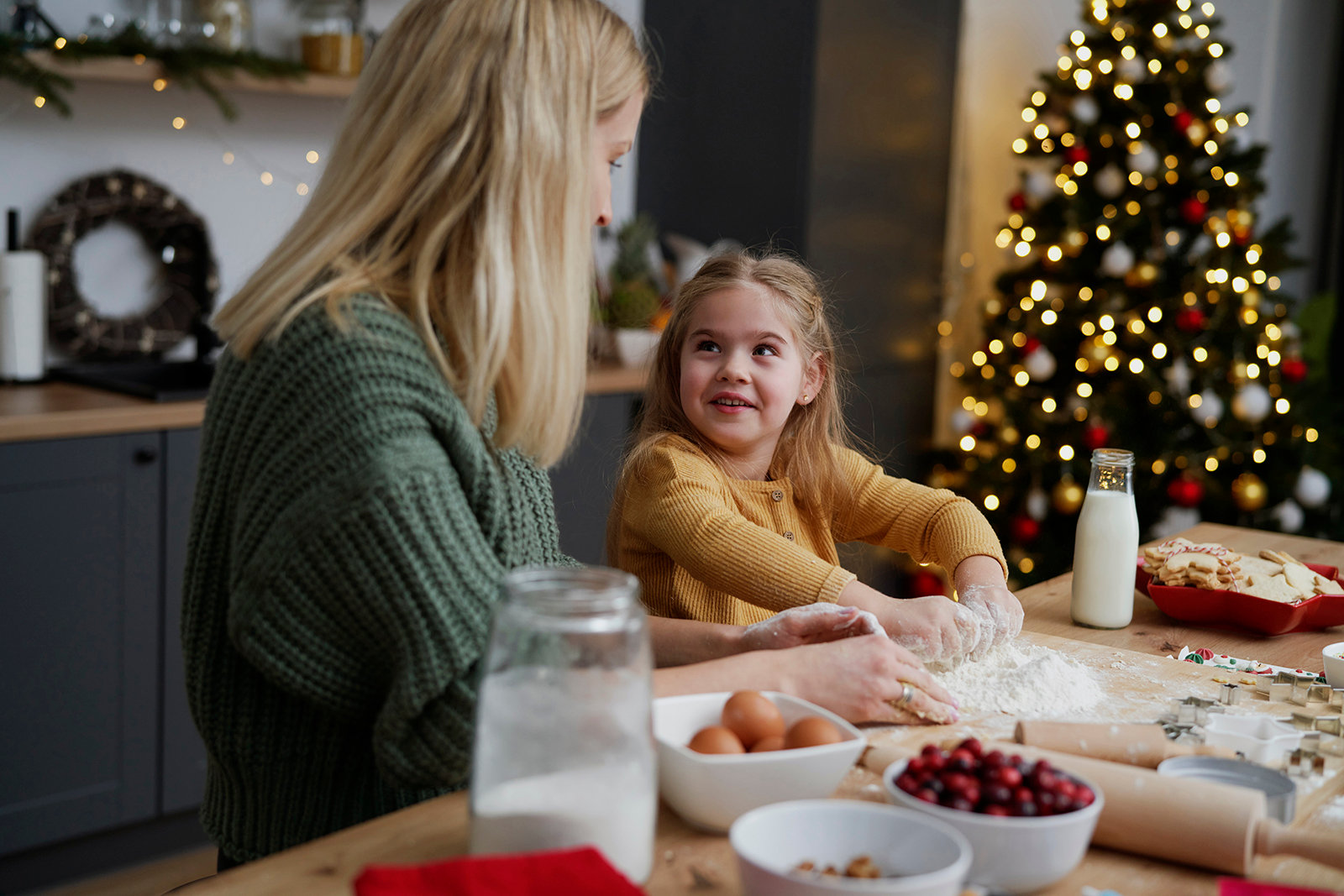 Mother and little daughter in the kitchen while baking