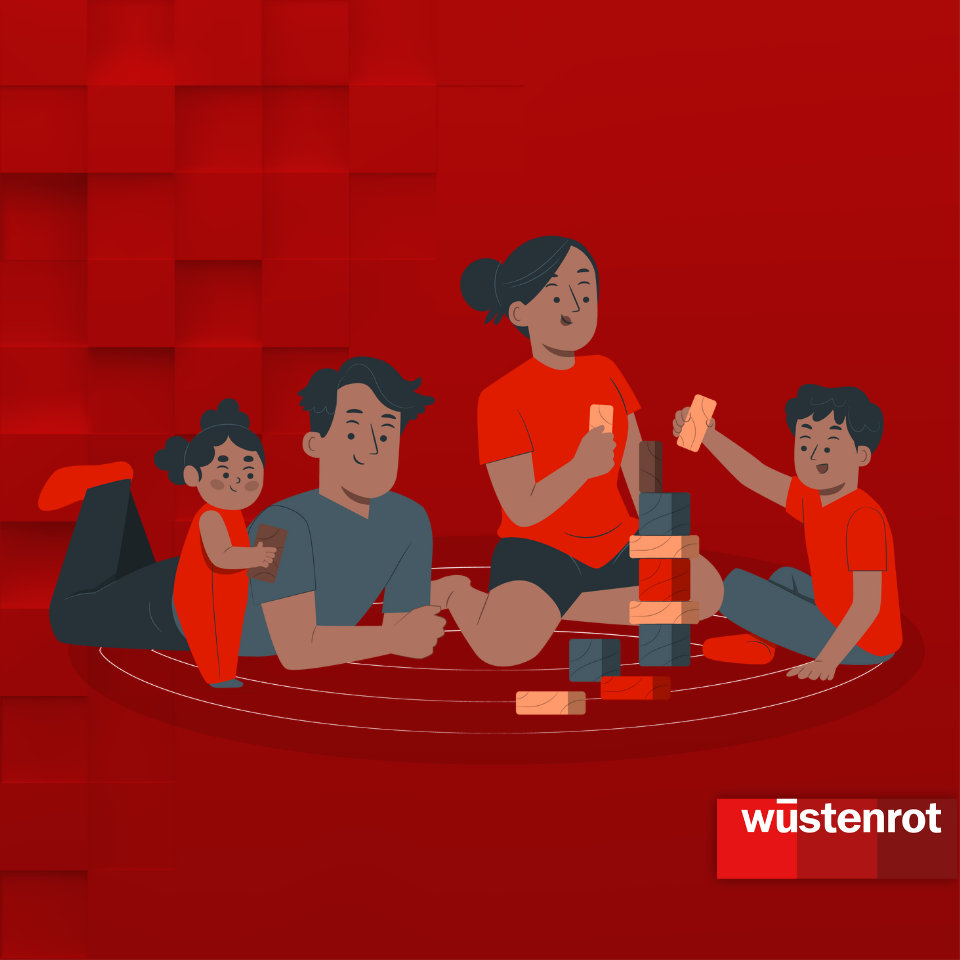 Familie mit Mutter, Vater und zwei Kindern sitzt am Boden und spielt mit Bauklötzen