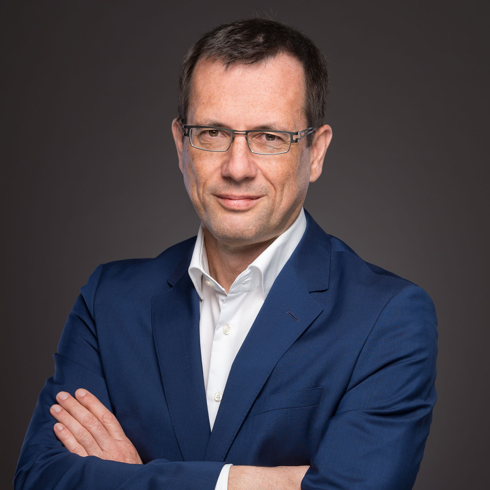 Mann im Anzug mit verschränkten Armen