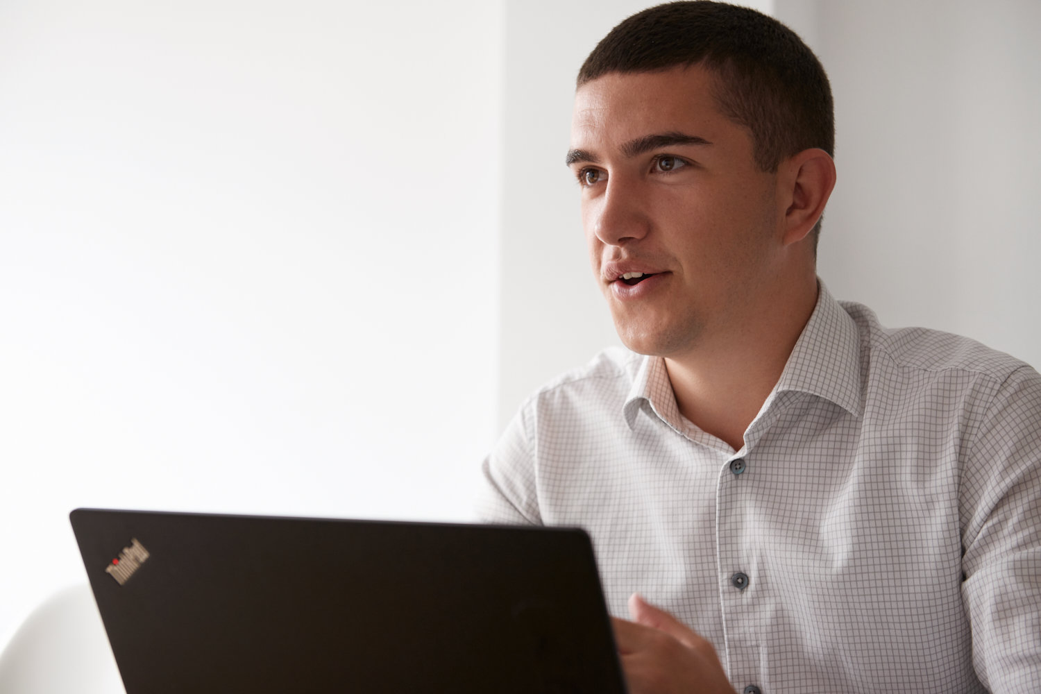 Mann im Hemd hat einen Laptop vor sich