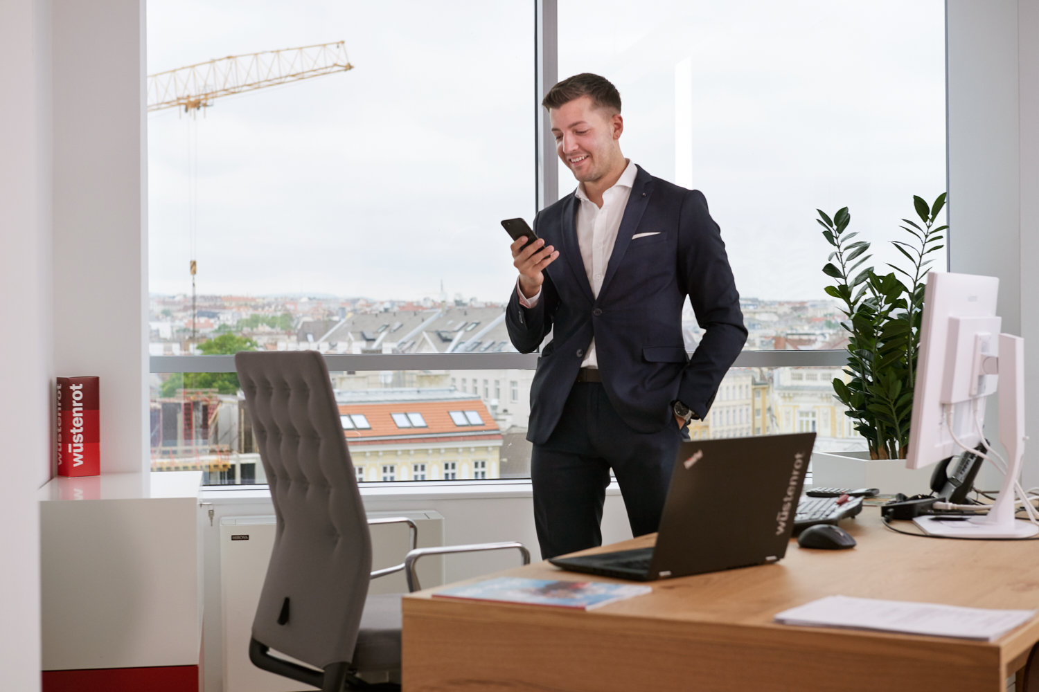 Mann im Anzug schaut auf sein Handy