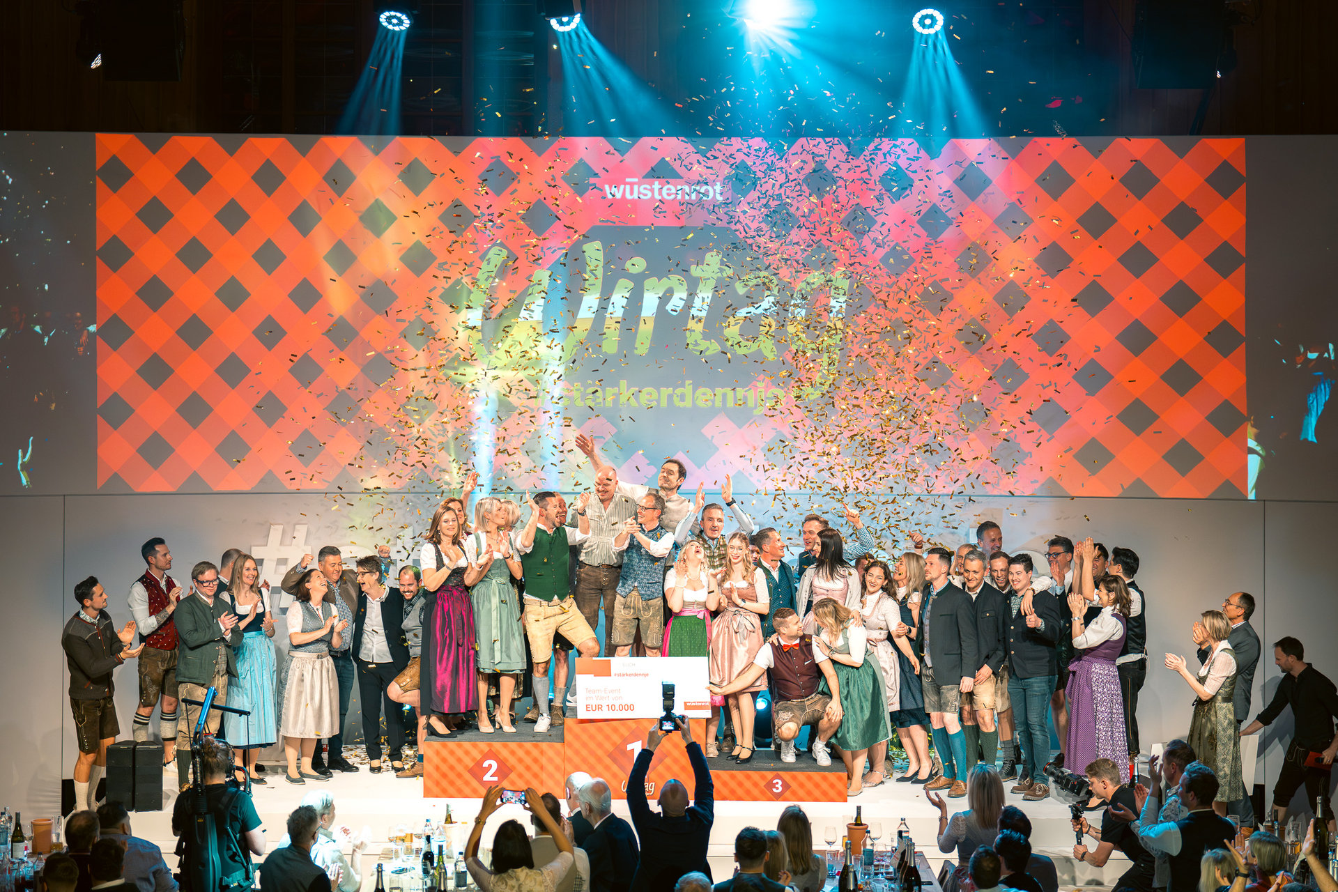 Mehrere Personen stehen auf eine Podium und feiern den Wirtag.