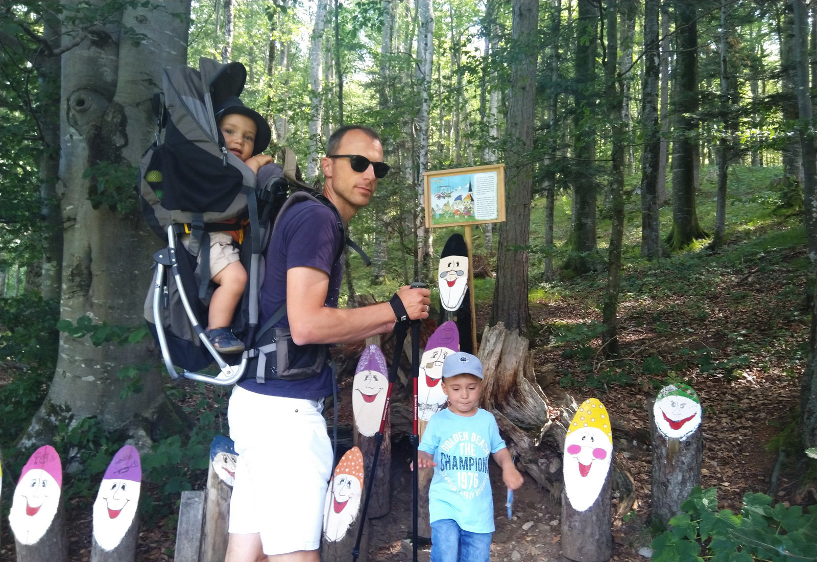 Ein Vater mit seinen zwei Söhnen unterwegs im Wald