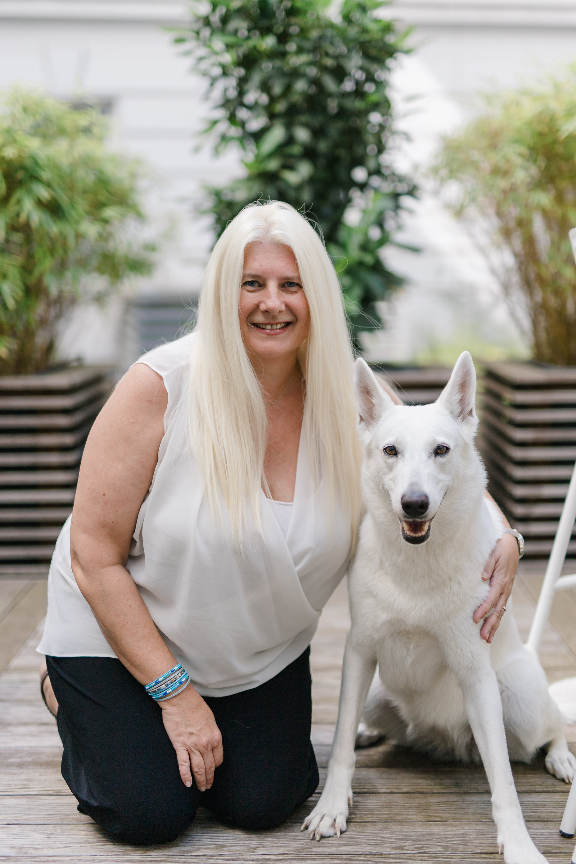 Mitarbeiterin posiert mit ihrem Hund im Innenhof