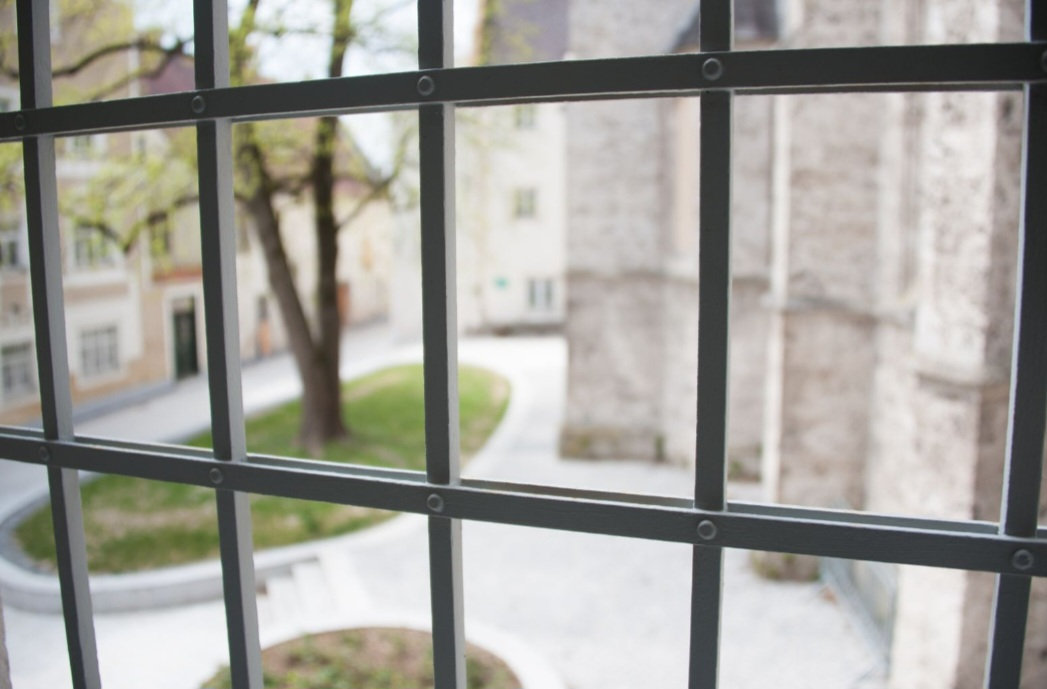 Ein Bild aus einer Gefängniszelle heraus, Gitterstäbe sind zu sehen