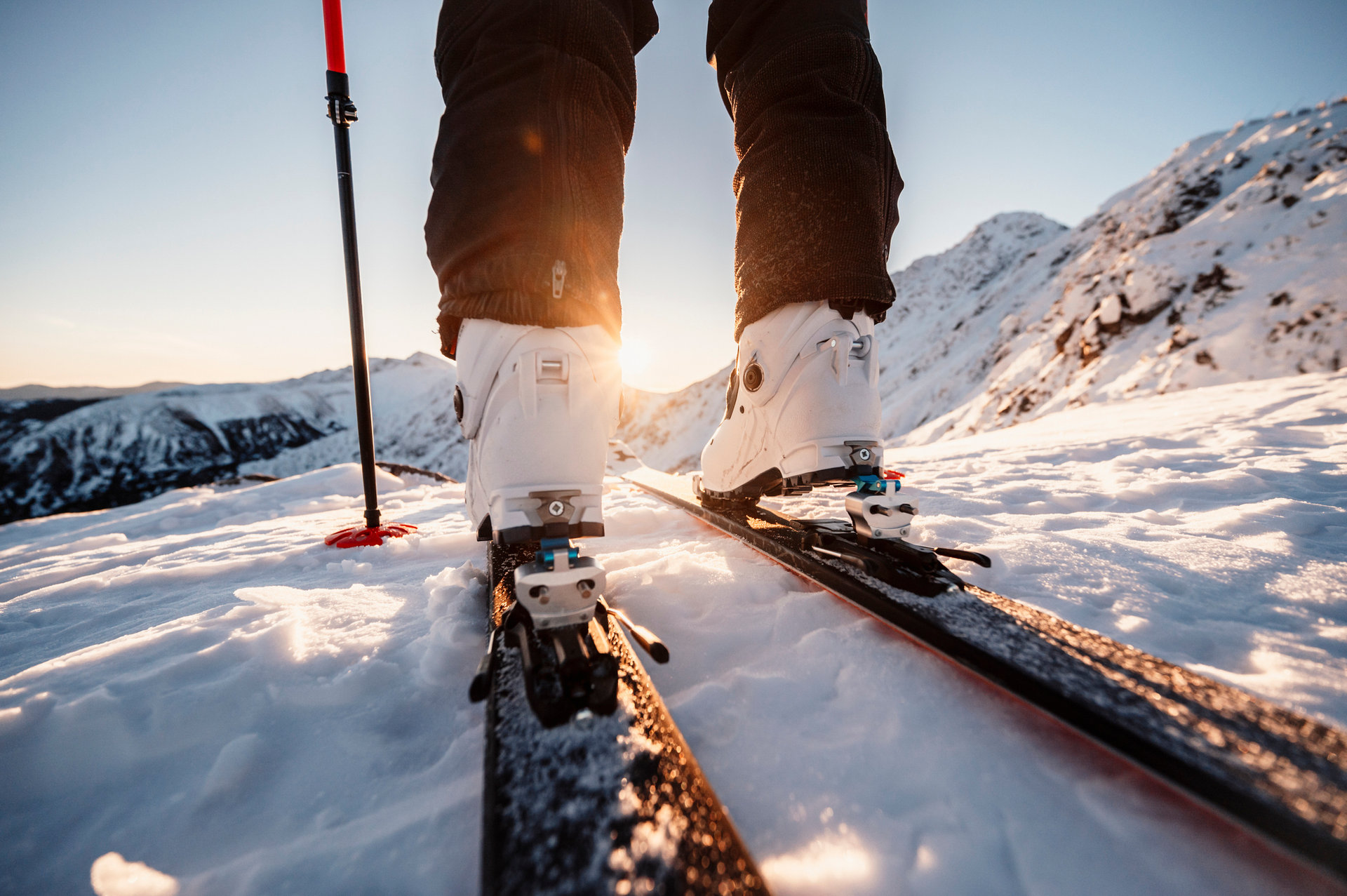 Mountaineer backcountry ski walking in the mountains. Ski touring in high alpine landscape. Adventure winter extreme sport. Detail boots.