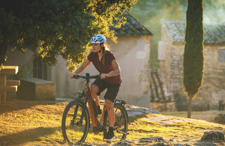 Frau auf Fahrrad mit Helm in der Natur