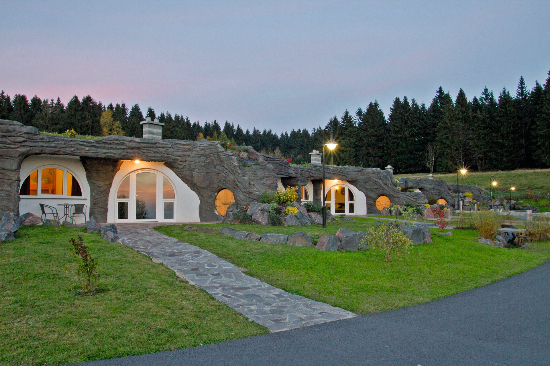 Einige Erdhäuser stehen nebeneinander. Drinnen brennt Licht.
