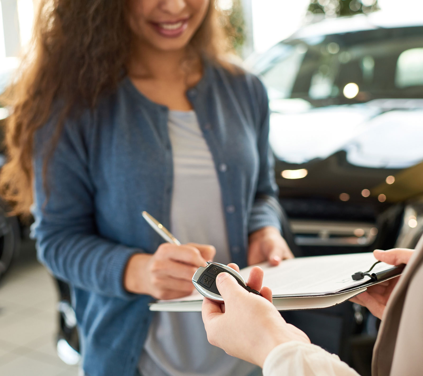Frau bekommt Autoschlüssel überreicht