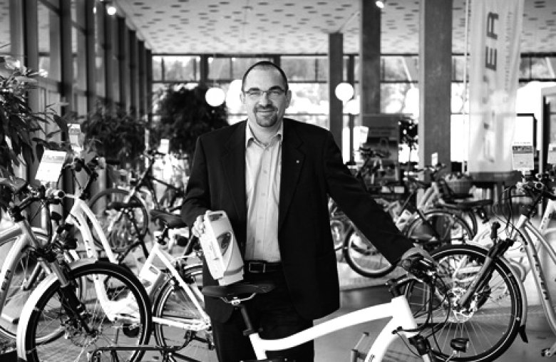 Mann in Anzug vor vielen Fahrrädern