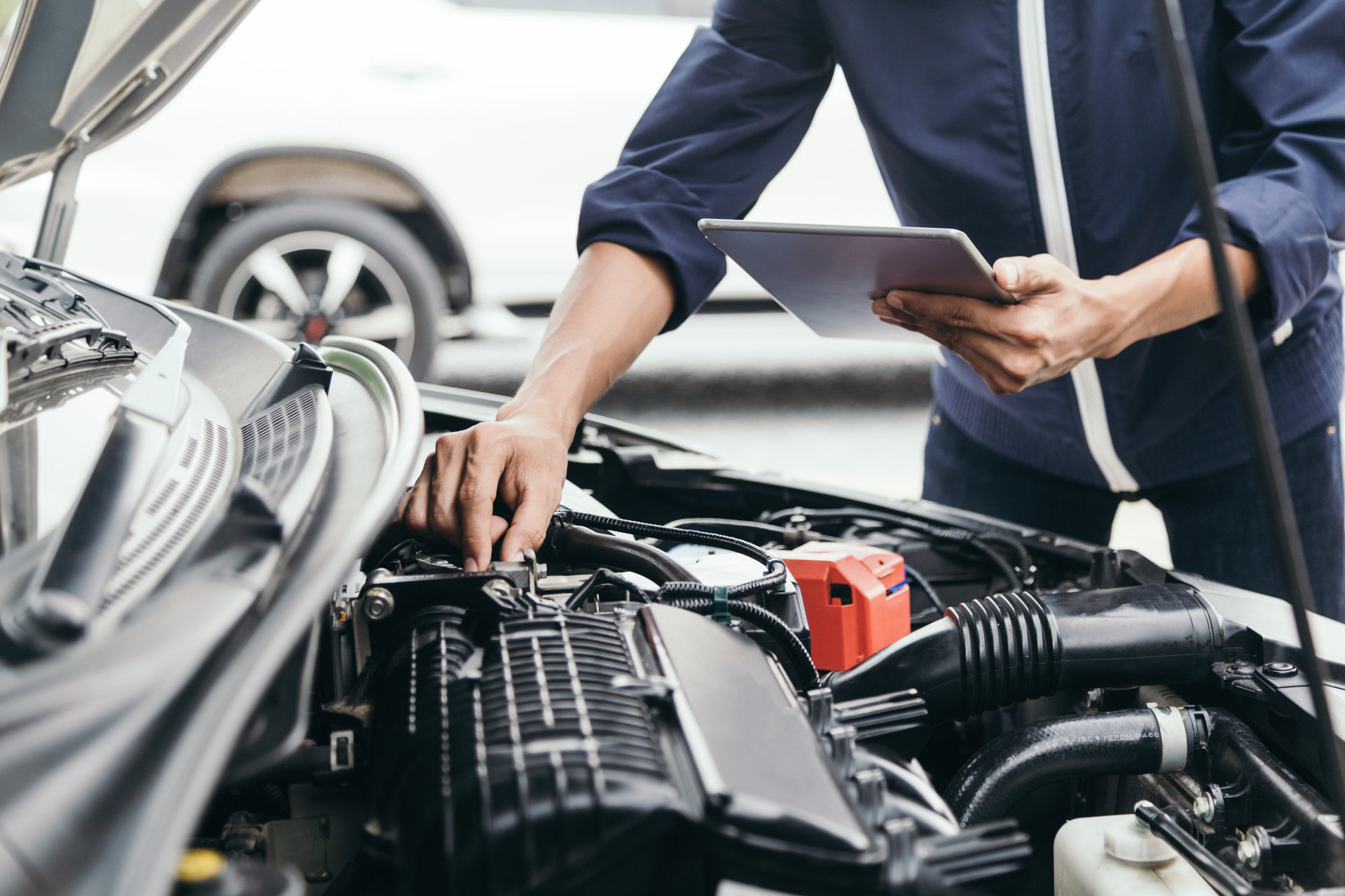 Time to say good bye Auto mit offener Haube und eine Mechaniker der am Motor arbeitet