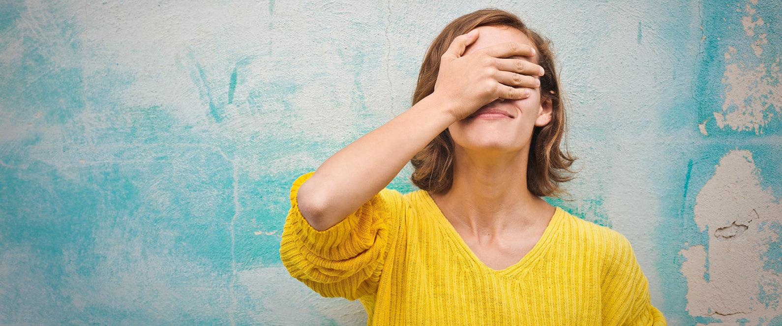 Junge Frau hält sich die Hand vor die Augen, da sie eine Fehler-Seite gestoßen ist.