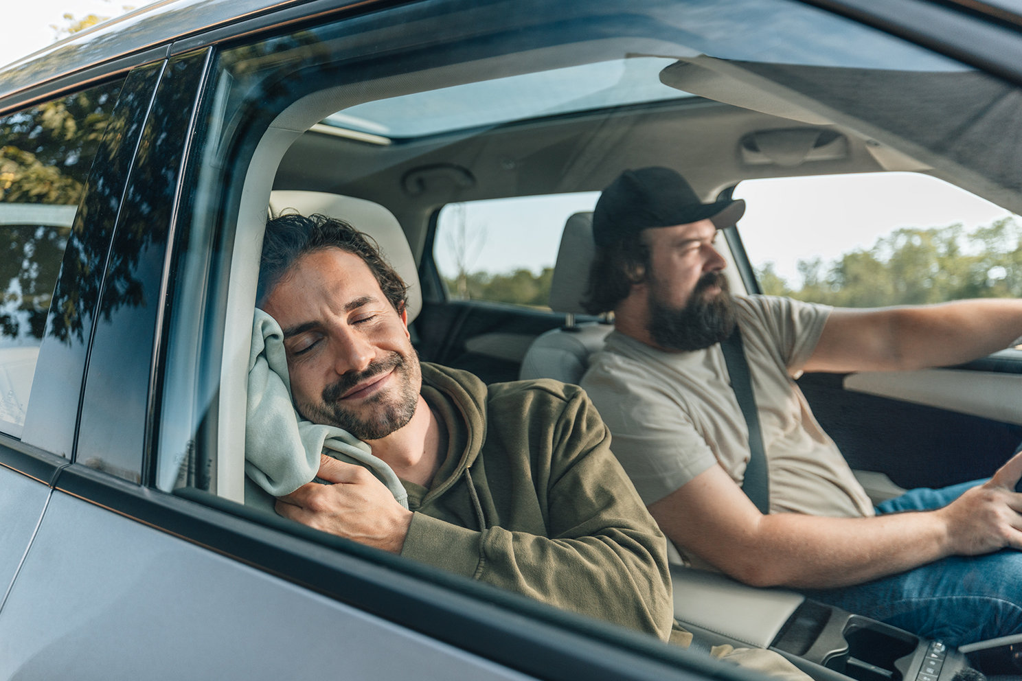 Zwei Personen sitzen entspannt in einem Auto. 