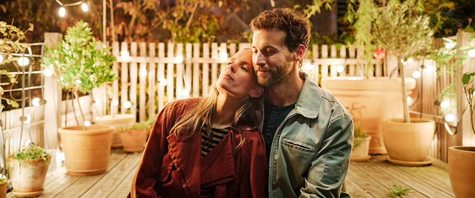 Mann und Frau umarmen sich auf Terrasse